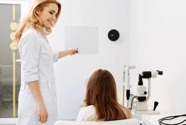 Güzel dost göz doktoruna bir muayenesinden iletken