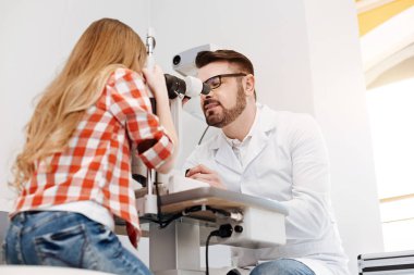 Hastaların gözleri gözlemleyerek çalışkan göz doktoruna konsantre