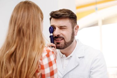 Gözleri dikkatle okuyan hoş dost doktor