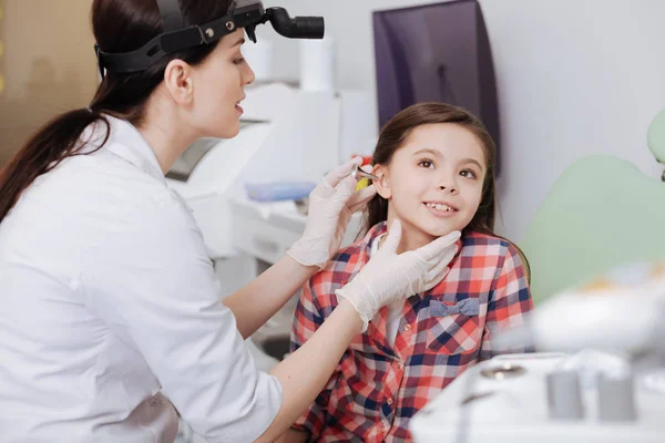 Aufmerksame Ärztin steckt Ohrtrichter ins Ohr ihrer Patientin — Stockfoto