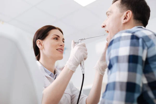 Otolaryngologue attrayant faisant examen de gorge du patient masculin — Photo
