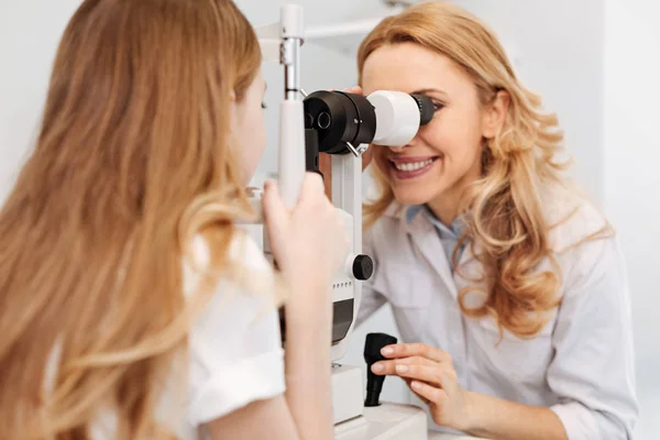 Neat capable ophthalmologist testing patients eyes — Stock Photo, Image