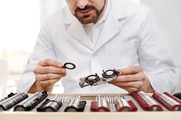 Encantador oftalmólogo escrupuloso recogiendo lentes correctas — Foto de Stock