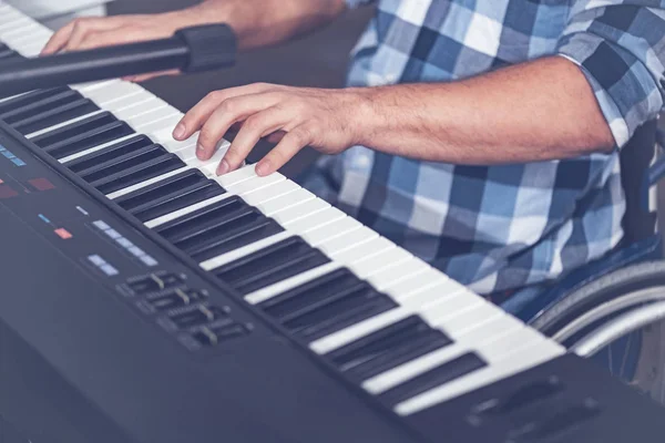 Unga funktionshindrade mannen spelar musikaliska tangentbord i studion — Stockfoto