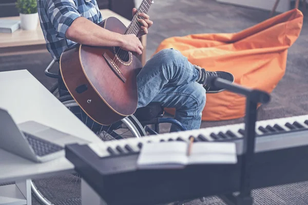 Joven handicap concentrado tocando instrumento musical en el estudio — Foto de Stock