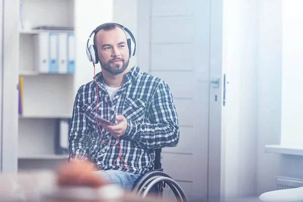 Sorrindo jovem handicap desfrutando de música em casa — Fotografia de Stock