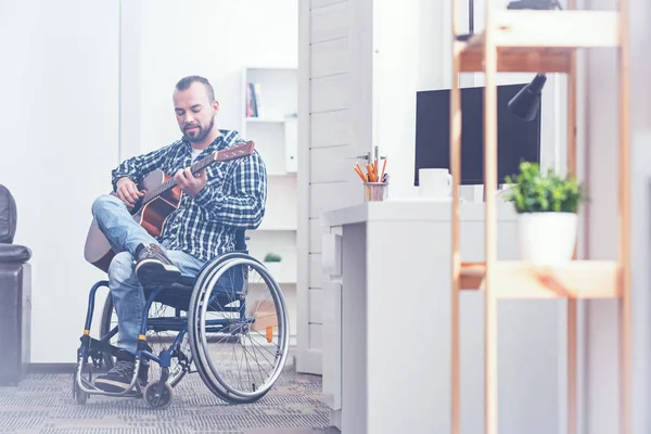 Encantado jovem inválido tocando guitarra em casa — Fotografia de Stock