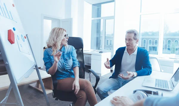 Hombre y mujer positivos discutiendo proyecto en la oficina — Foto de Stock