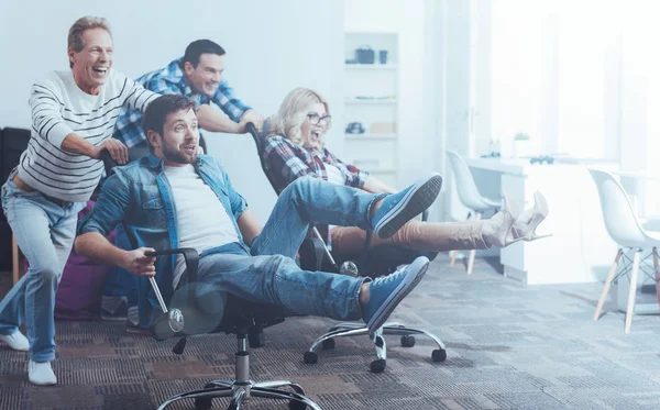 Büroarbeiter amüsieren sich mit einem Drehstuhl — Stockfoto