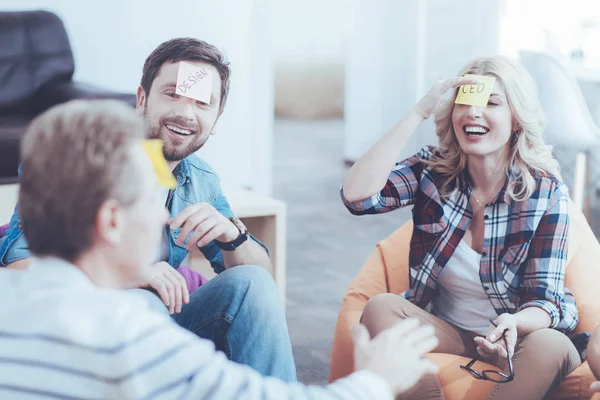 Vrolijke collega's speelspel met stickers op de voorhoofd — Stockfoto