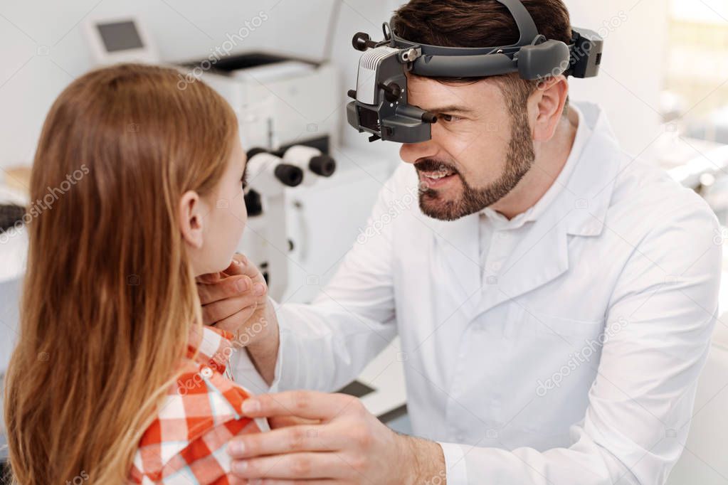 Concentrated competent expert examining girls eyes