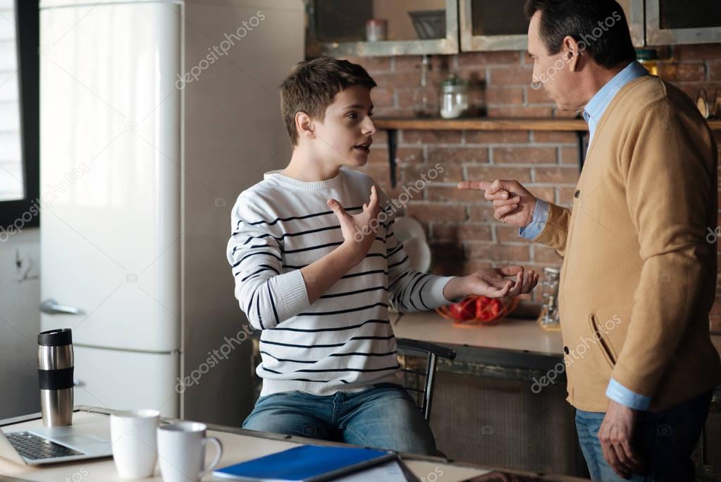 Shocked boy putting himself right with his father
