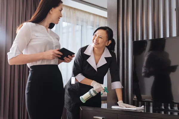 Alegre agradable mujer de negocios hablando con una camarera de hotel —  Fotos de Stock