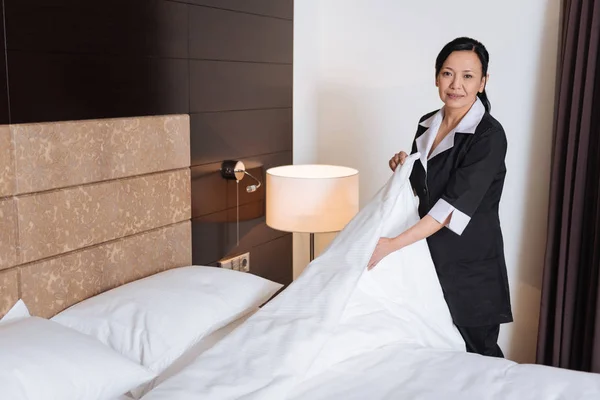 Nice pleasant woman cleaning the hotel room — Stock Photo, Image