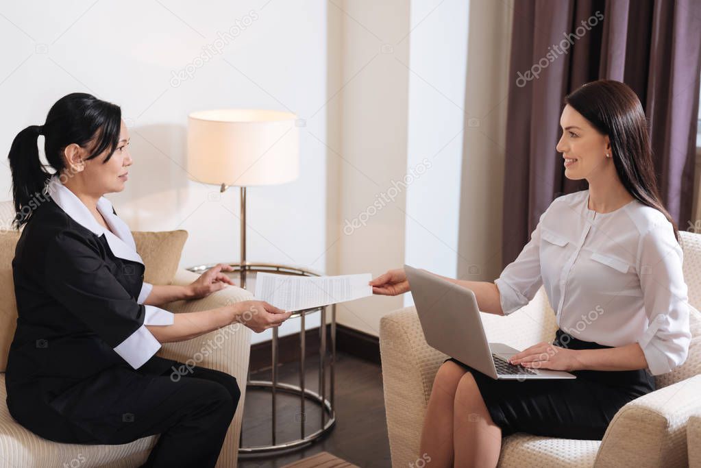 Delighted nice hotel maid taking an employment contract