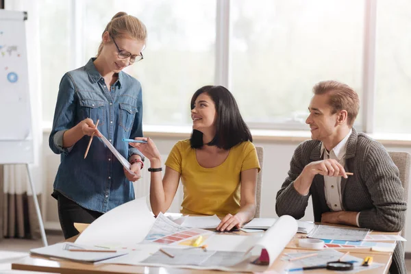 Mujer encantada positiva señalando el boceto —  Fotos de Stock