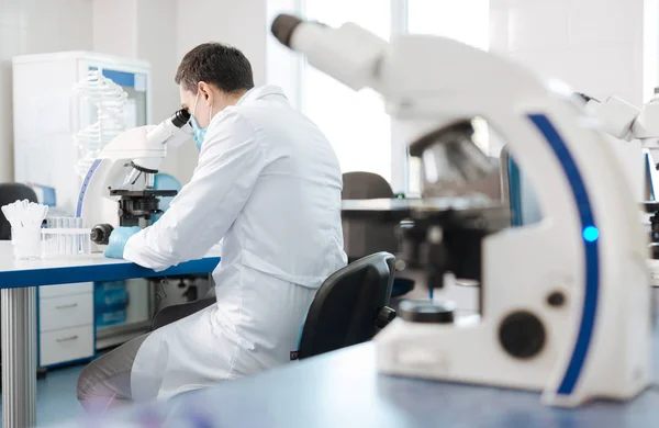 Confident researcher looking into ocular — Stock Photo, Image