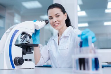 Güzel esmer reaktifler incelemek için mikroskop kullanarak