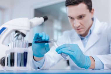 Mavi sıvı dökme özenli laboratuar asistanı