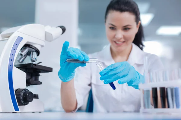 Positivo felice scienziato femminile aggiungendo polvere al reagente — Foto Stock
