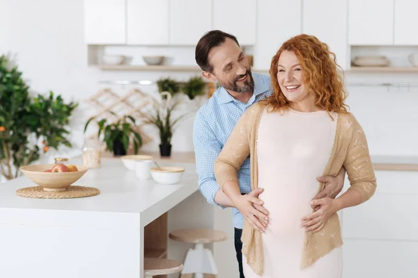 Marito abbracciando la sua moglie incinta a tempo pieno — Foto Stock
