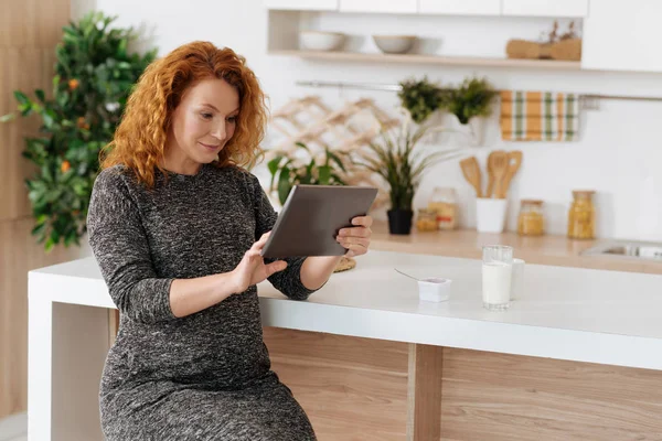 Curly-haired blivande kvinna som arbetar på digitala tablett — Stockfoto