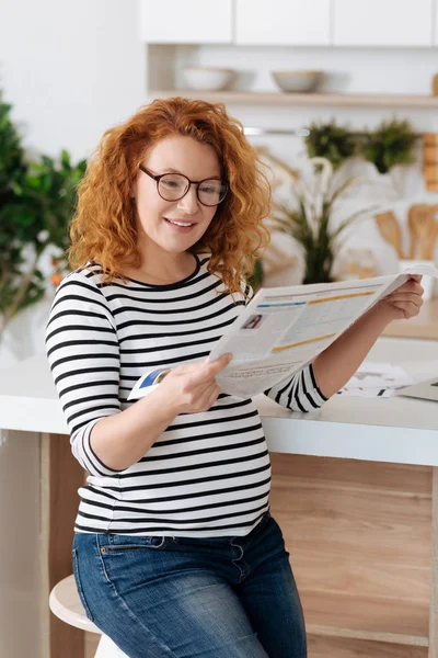 Lockige Preggy Zeitung lesen — Stockfoto