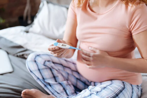 Close up of expecting mom holding thermometer — Stock Photo, Image