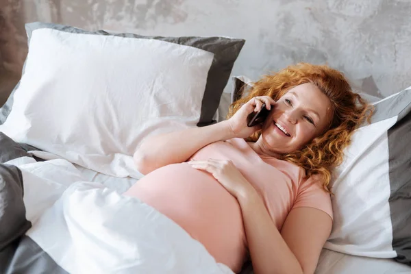 Беременная женщина разговаривает по мобильному телефону — стоковое фото