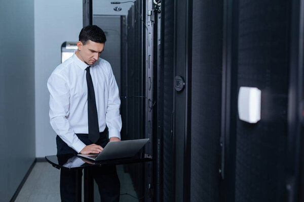 Симпатичный мужчина, работающий с ноутбуком.
