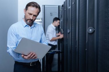 Dizüstü bilgisayar ekranına bakarak güzel ciddi programcı