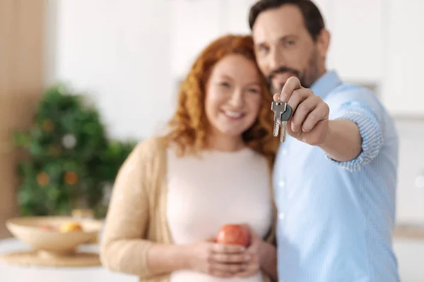 Esposo radiante y esposa sosteniendo las llaves de una casa nueva — Foto de Stock