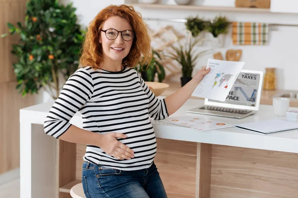 Fullgångna gravid kvinna poserar med dokument — Stockfoto