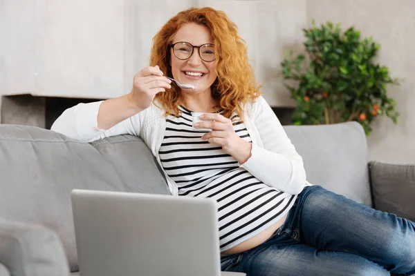 Trefalt lycklig gravid kvinna äta yoghurt — Stockfoto