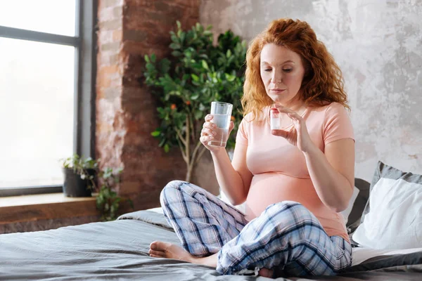 Femmes enceintes matures prenant des médicaments avec de l'eau — Photo