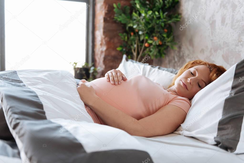 Prospective mother having sweet dreams at bedtime