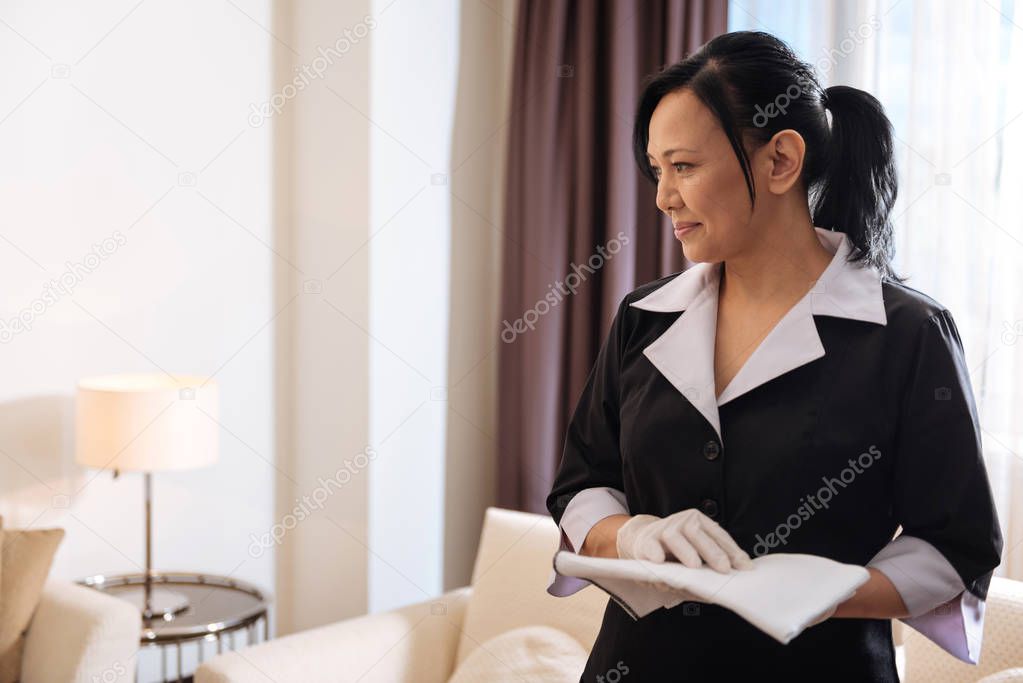 Asian hotel maid cleaning room