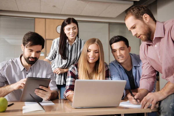 Positiv glad kollegor tittar på skärmen på laptop — Stockfoto