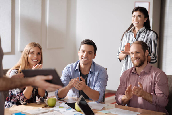 Positive collective congratulating their friend