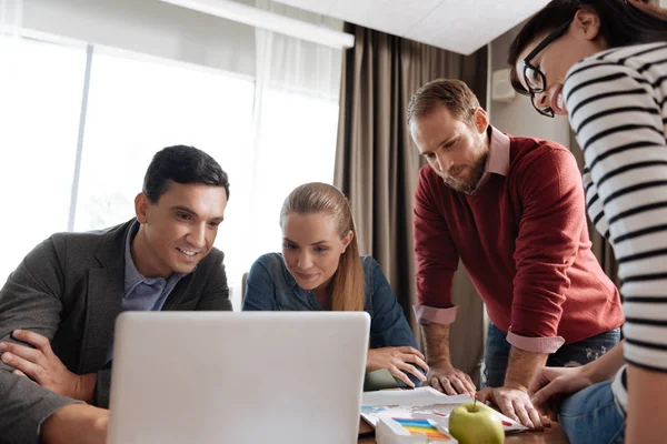 Attentive young collective looking at screen of laptop — Stock Photo, Image