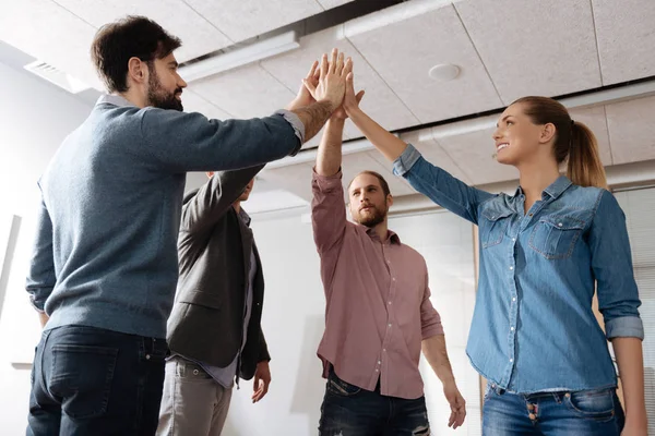 Glad kommando för unga arbetstagare att höja händerna tillsammans — Stockfoto