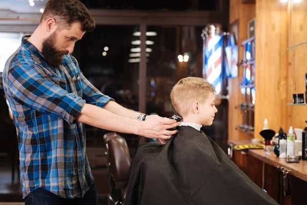 Cabeleireiro experiente fazendo o corte de cabelo para menino — Fotografia de Stock
