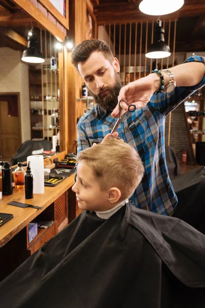 Barbeiro fazendo o corte de cabelo para criança — Fotografia de Stock