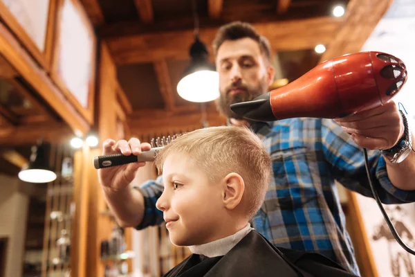 Bonito menino positivo visitando um cabeleireiro — Fotografia de Stock