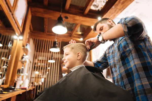 経験豊富な深刻な美容師の少年の髪をとかす — ストック写真