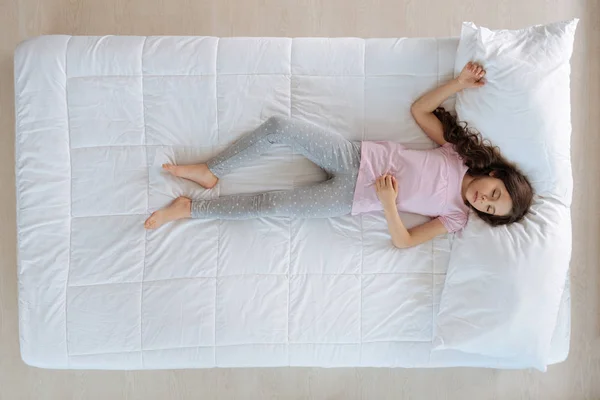 Linda menina agradável deitado na cama — Fotografia de Stock