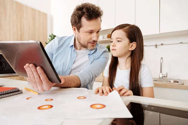 Father showing something on a tablet to his daughter — Stock Photo, Image