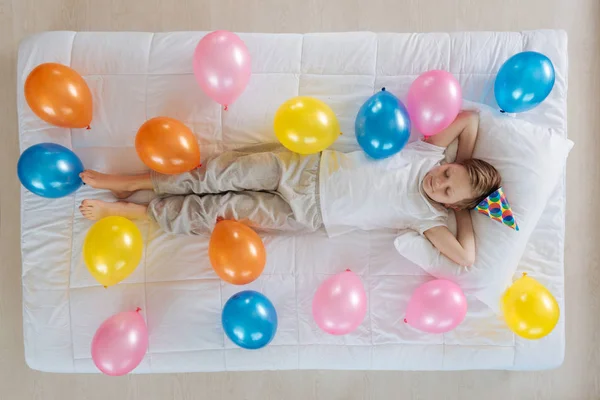 Chlapec spí na posteli s balónky — Stock fotografie