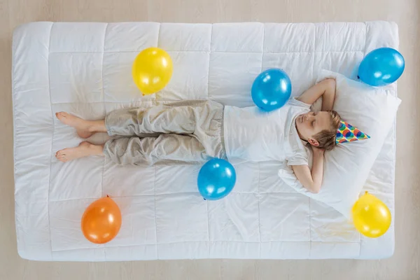 Chlapec spí na posteli s balónky — Stock fotografie