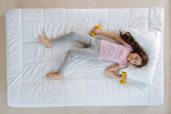 Niña sosteniendo pesas — Foto de Stock